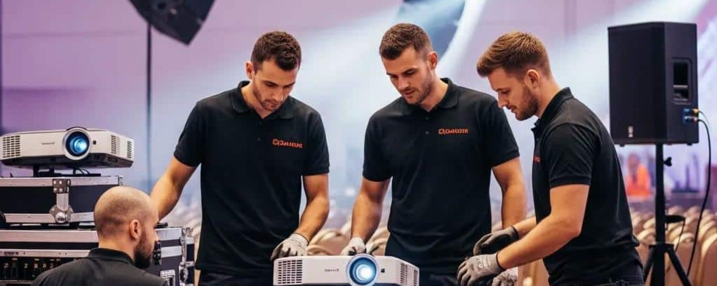 Professional AV installation team setting up equipment for an event